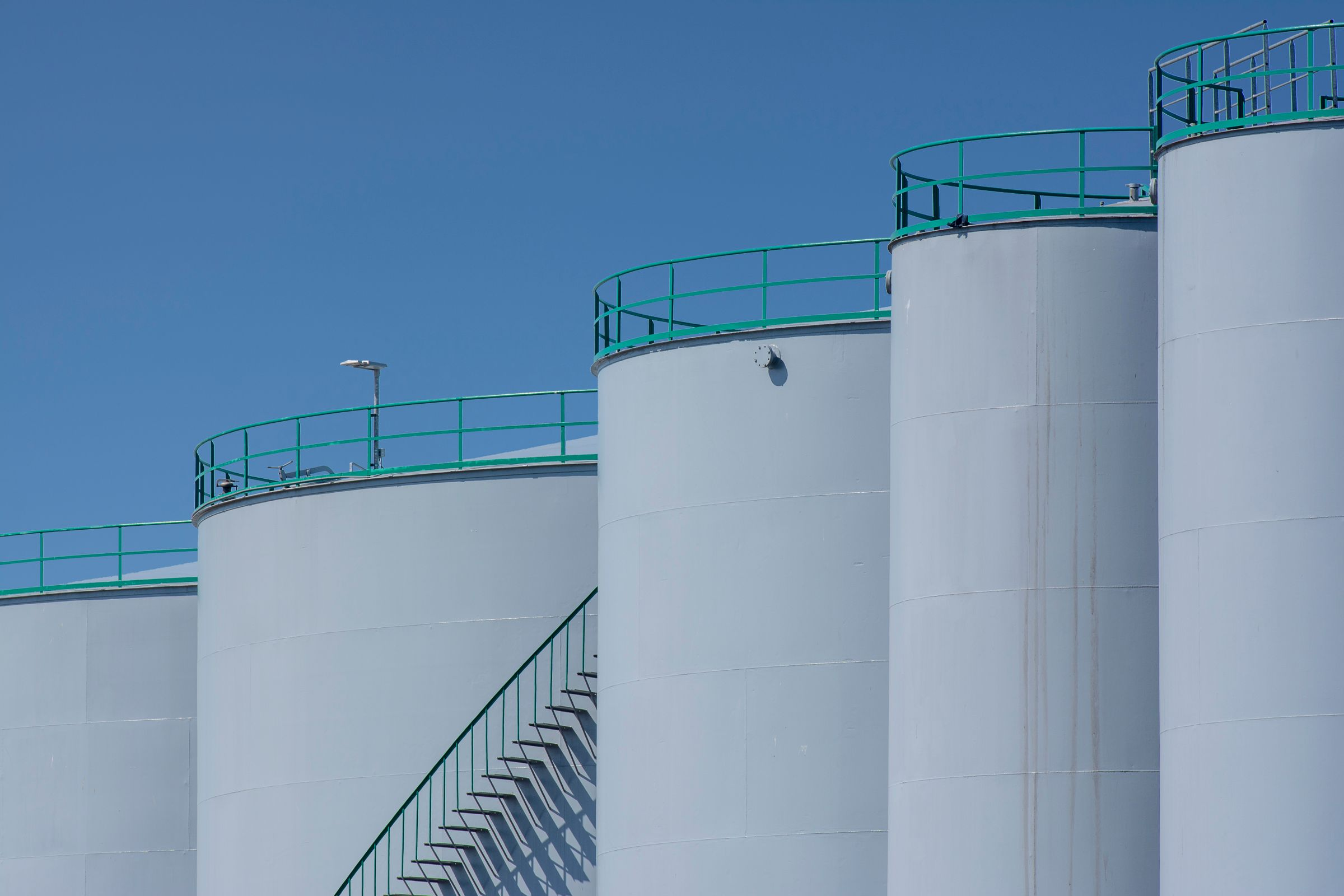 White storage tanks against a blue sky