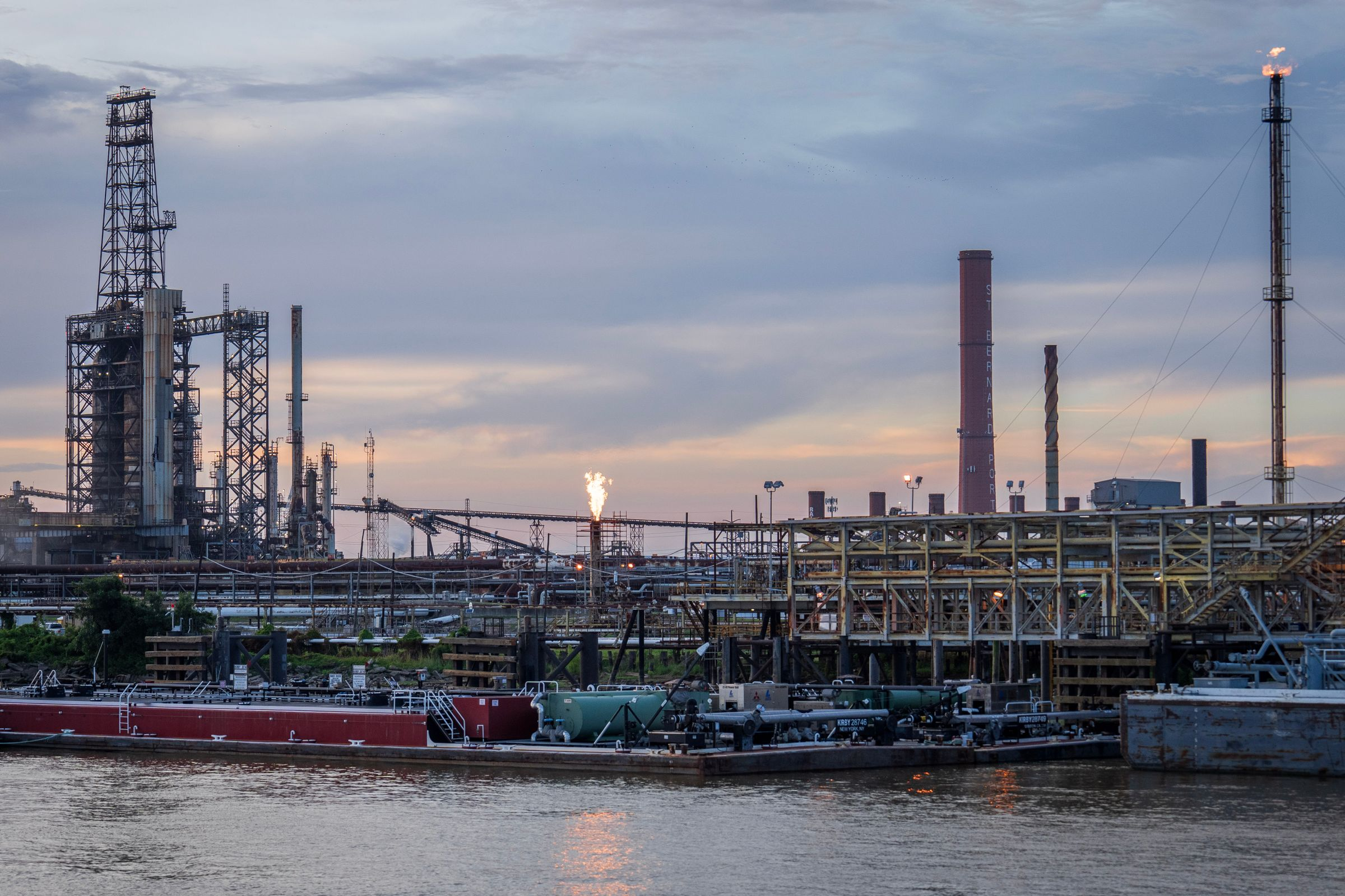 Industrial complex by a river at sunset