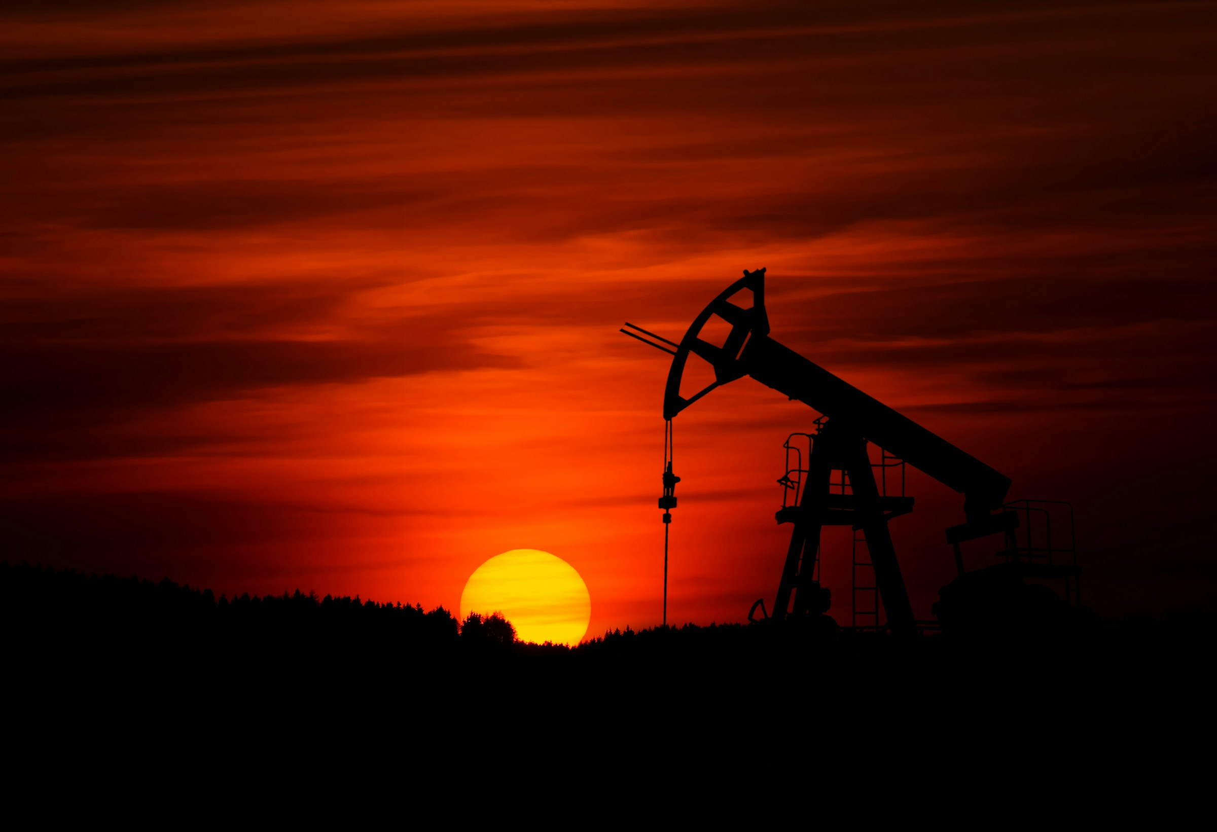 Pumpjack silhouetted against a red sunset