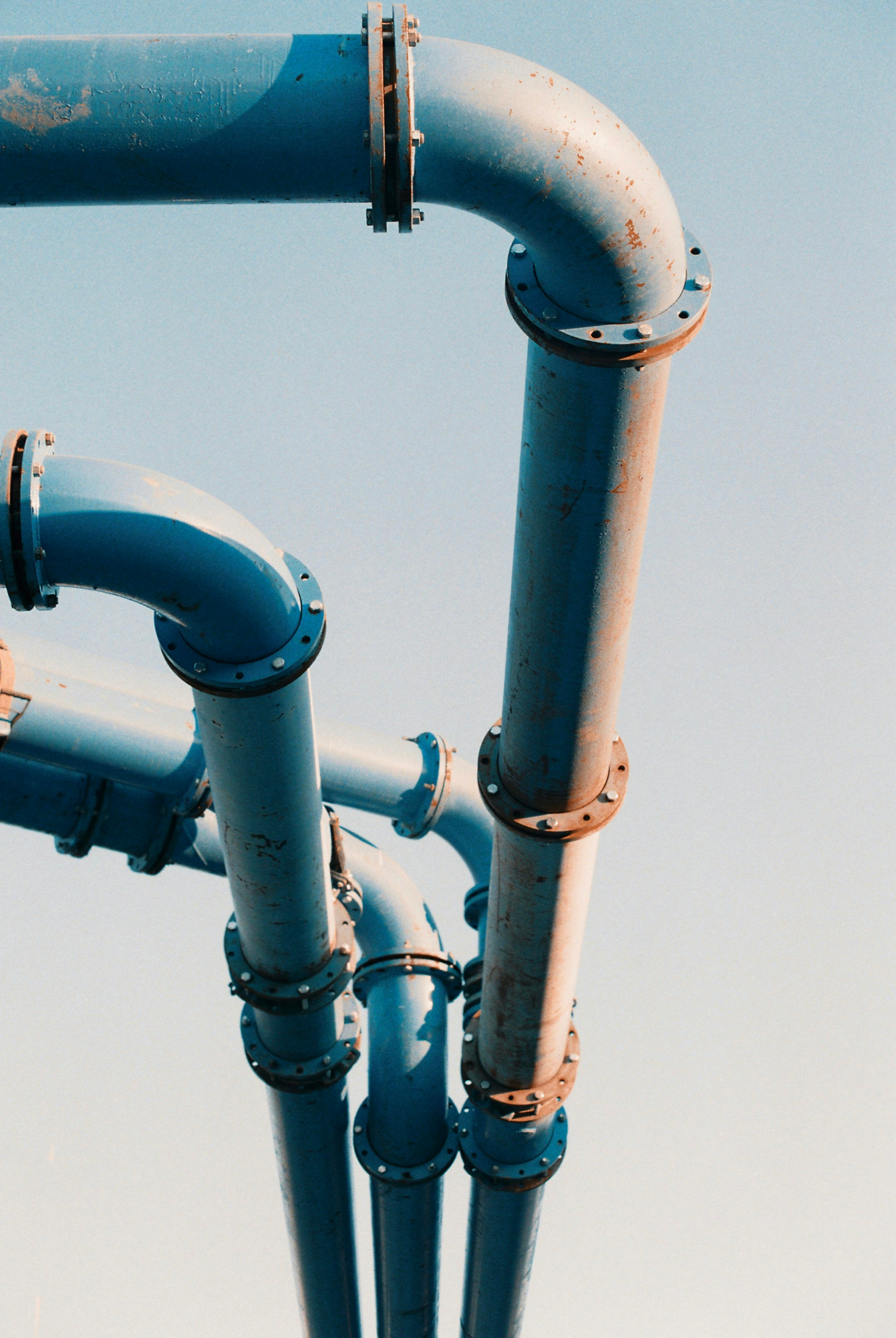 Blue and white pipework against the sky
