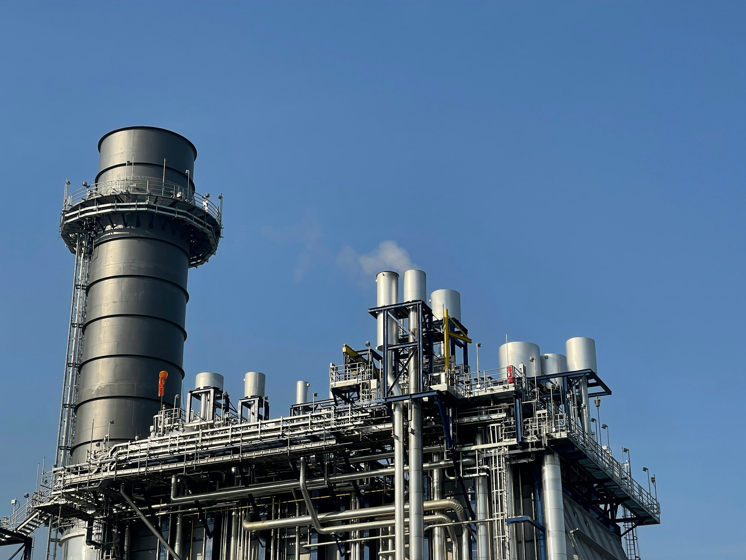 Processing tower against a blue sky, illustrative