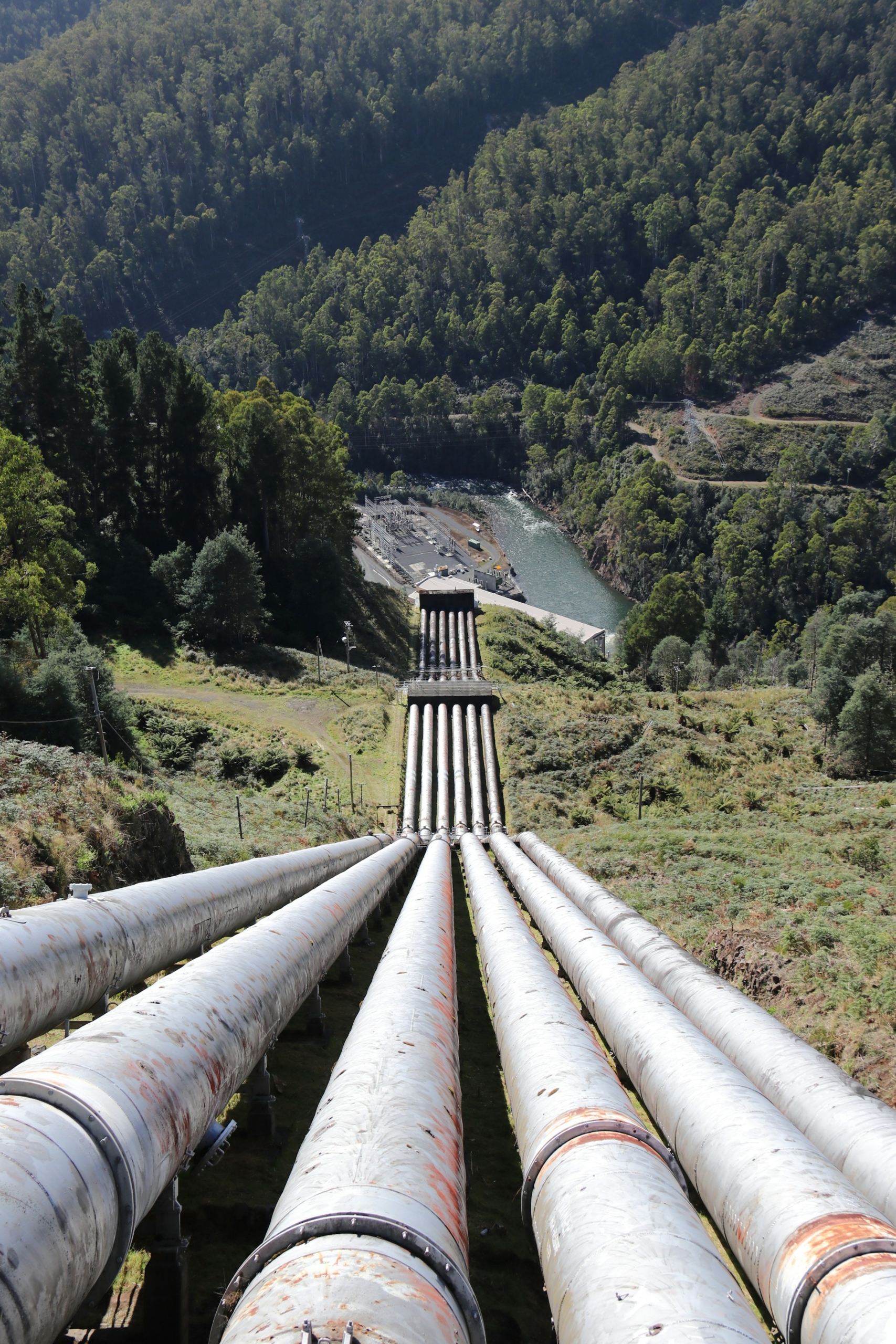Pipelines running down a green valley