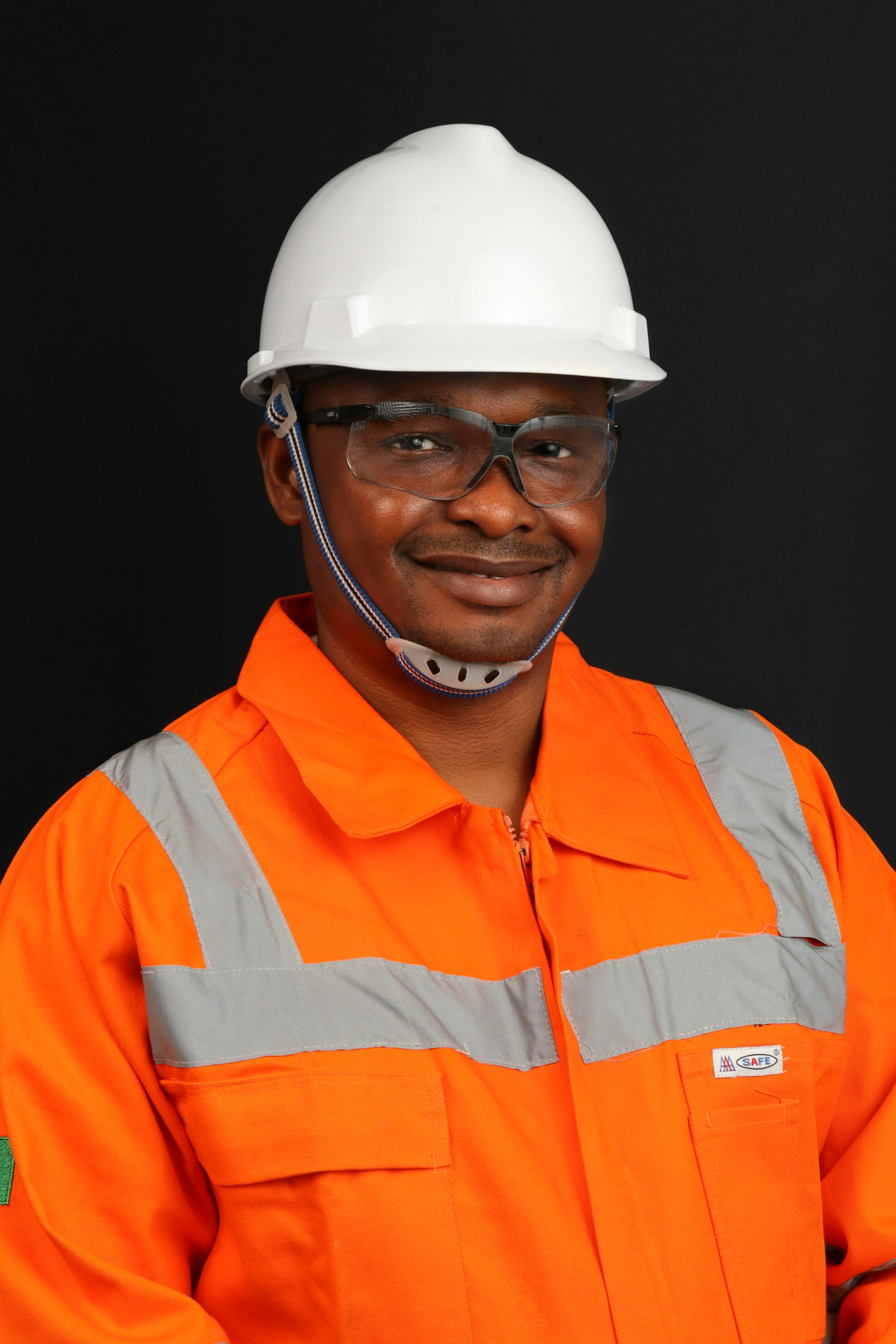 Smiling engineer in orange high-visibility workwear and safety glasses
